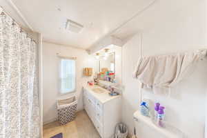 Full bathroom featuring vanity, a textured ceiling, and a shower with curtain