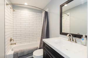Full bath with shower / bath combination with curtain, vanity, and recessed lighting