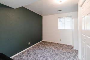 Unfurnished bedroom with a closet, carpet floors, and a textured ceiling