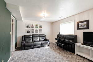 Living area with carpet floors and a textured ceiling