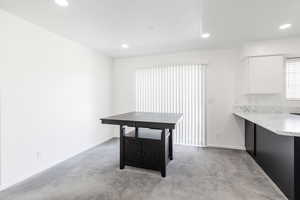 Unfurnished dining area featuring light colored carpet and recessed lighting