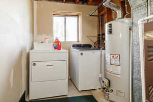Laundry room with gas water heater, separate washer and dryer, and heating unit