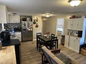 Dining space featuring light wood-style floors, a textured ceiling, and crown molding