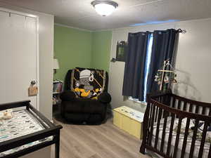 Bedroom with wood finished floors and a textured ceiling