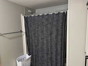 Bathroom featuring a textured ceiling and a shower with curtain