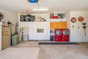 Garage with separate washer and dryer, strapped water heater, and ceiling fan