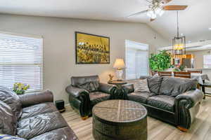 Living room with ceiling fan, lofted ceiling, LVP floors, and recessed lighting