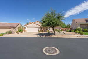 View of front of home with driveway, stucco siding, a tiled roof, and an attached garage
