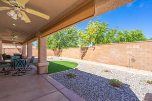 Fenced backyard featuring ceiling fan and a patio area