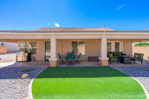 Rear view of property featuring a patio, stucco siding, a tile roof, and outdoor lounge area