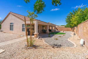 Back of house featuring stucco siding, a fenced backyard, and a patio