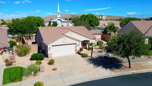 View of front of home featuring stucco siding, a garage, driveway, and a tiled roof