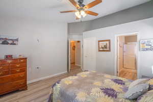Primary Bedroom with light wood-style floors, connected bathroom, and a ceiling fan