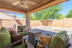 Fenced backyard with an outdoor hangout area, a patio, and ceiling fan