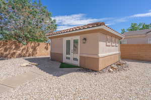 Detached casita featuring a fenced backyard, stucco siding, a tile roof, and french doors