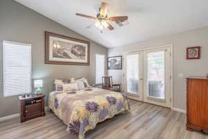 Primary Bedroom featuring vaulted ceiling, access to exterior, french doors, LVP floors, and ceiling fan