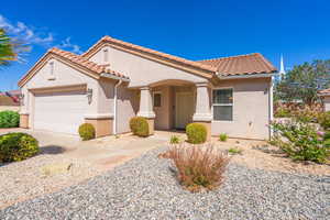 Mediterranean / spanish-style home with stucco siding, a garage, a tiled roof, and driveway