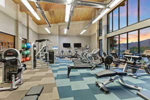 Workout area with a towering ceiling and carpet flooring