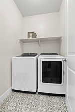 Washroom featuring separate washer and dryer, light tile patterned floors, and a textured ceiling