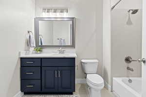 Full bathroom with vanity, washtub / shower combination, and light tile patterned floors