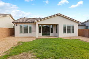 Back of property featuring a fenced backyard, a patio area, stucco siding, and a tiled roof