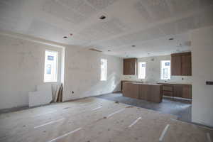 Kitchen with brown cabinetry, a center island, and open floor plan