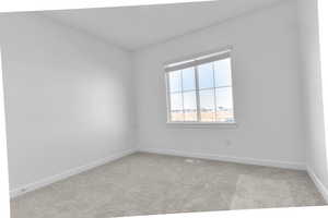 Empty room with light colored carpet and baseboards