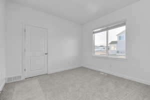 Unfurnished room featuring baseboards and light carpet
