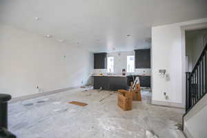 Living area featuring a textured ceiling and stairway