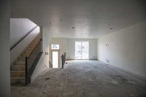 Unfurnished living room featuring baseboards and a textured ceiling