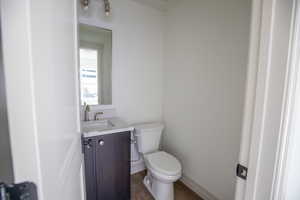 Half bath with vanity and dark wood-style flooring