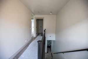 Corridor featuring a textured ceiling and unfinished concrete floors