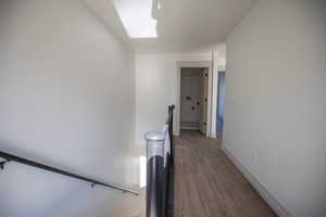 Hallway featuring a skylight and dark wood-type flooring