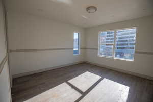 Unfurnished room featuring hardwood / wood-style floors and baseboards