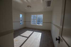 Empty room featuring hardwood / wood-style floors and cooling unit