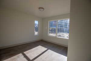 Unfurnished room featuring wood finished floors and baseboards
