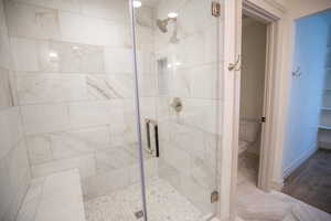 Full bath with a shower stall and marble finish floors