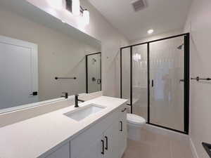 Bathroom with a stall shower, vanity, and light tile patterned flooring
