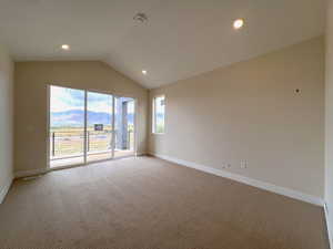 Owner's suite featuring vaulted ceiling, light colored carpet, a mountain view, and sliding door to covered balcony.