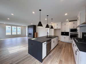 Kitchen featuring chef's kitchen, pendant lighting, white cabinetry and Kitchen Aid appliances.