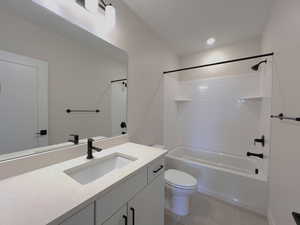 Bathroom featuring washtub / shower combination, light tile patterned flooring, and vanity