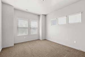 Carpeted empty room with baseboards