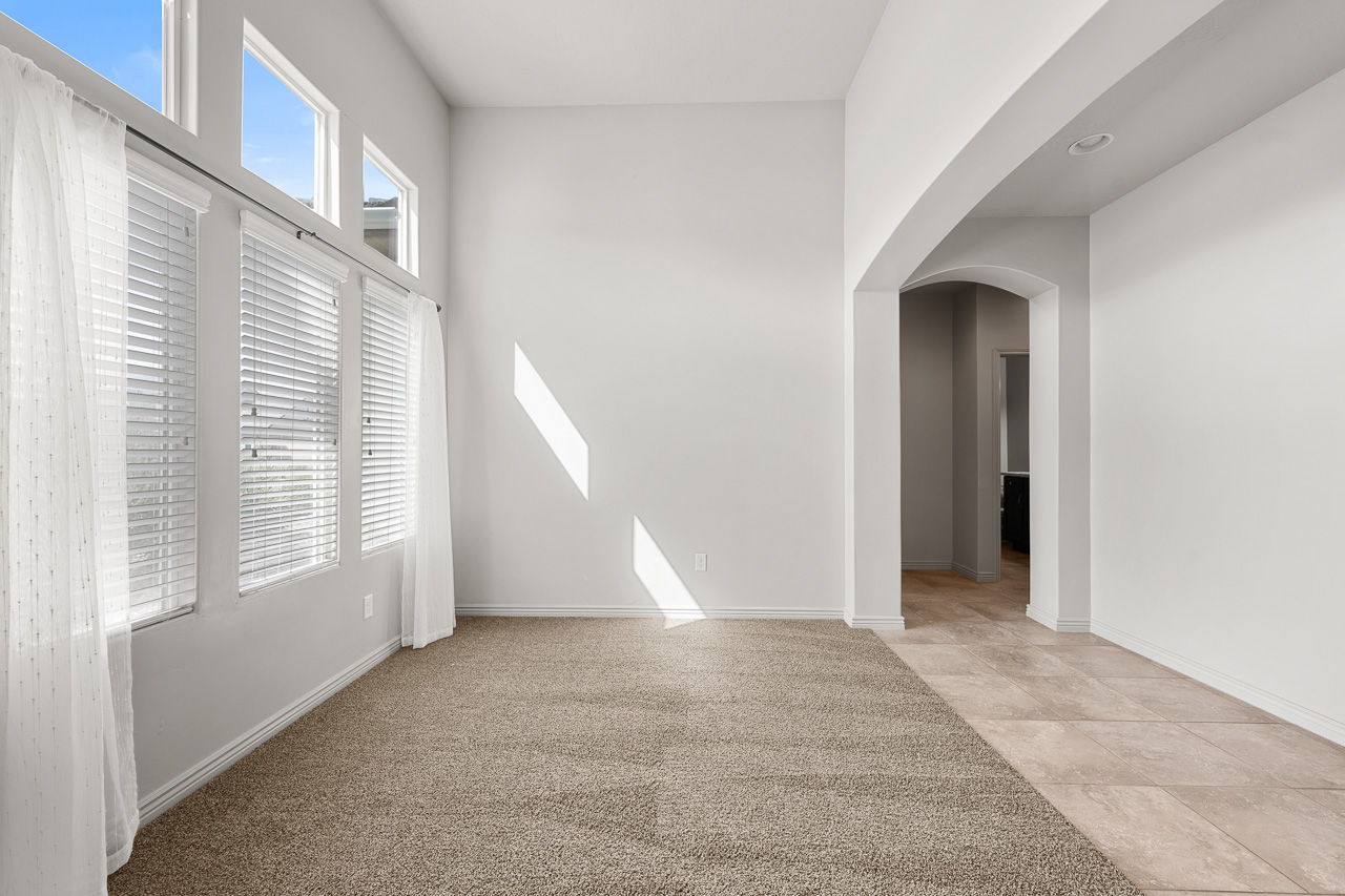 Empty room with arched walkways and light carpet
