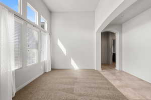 Empty room with arched walkways and light carpet