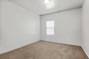 Unfurnished room featuring carpet floors and a textured ceiling