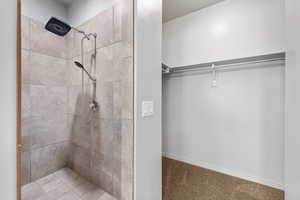 Bathroom featuring a stall shower and a walk in closet