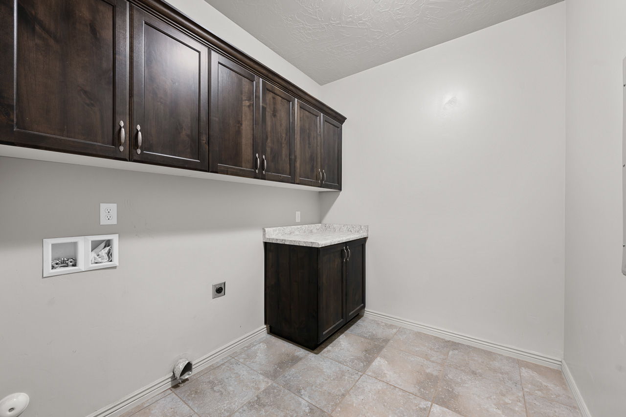 Washroom with cabinet space, a textured ceiling, washer hookup, and electric dryer hookup