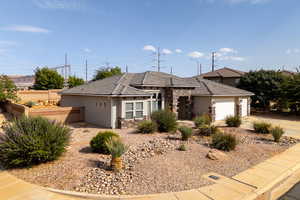 View of front of house featuring stone siding, an attached garage, stucco siding, a tile roof, and driveway