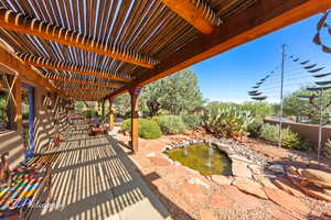 View of patio / terrace with a pergola and a garden pond