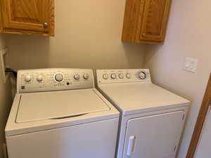 Laundry area featuring cabinet space and washer and clothes dryer